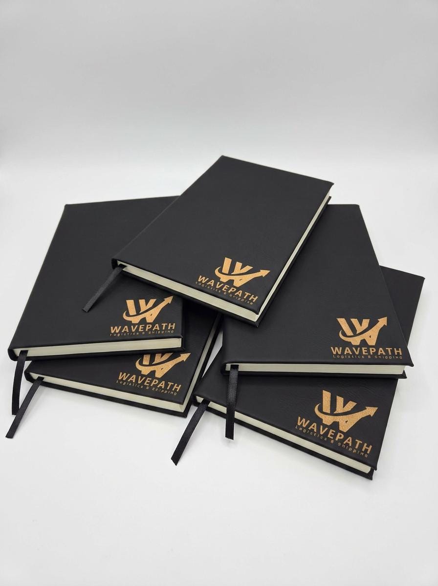 Stack of black journals engraved with a company logo