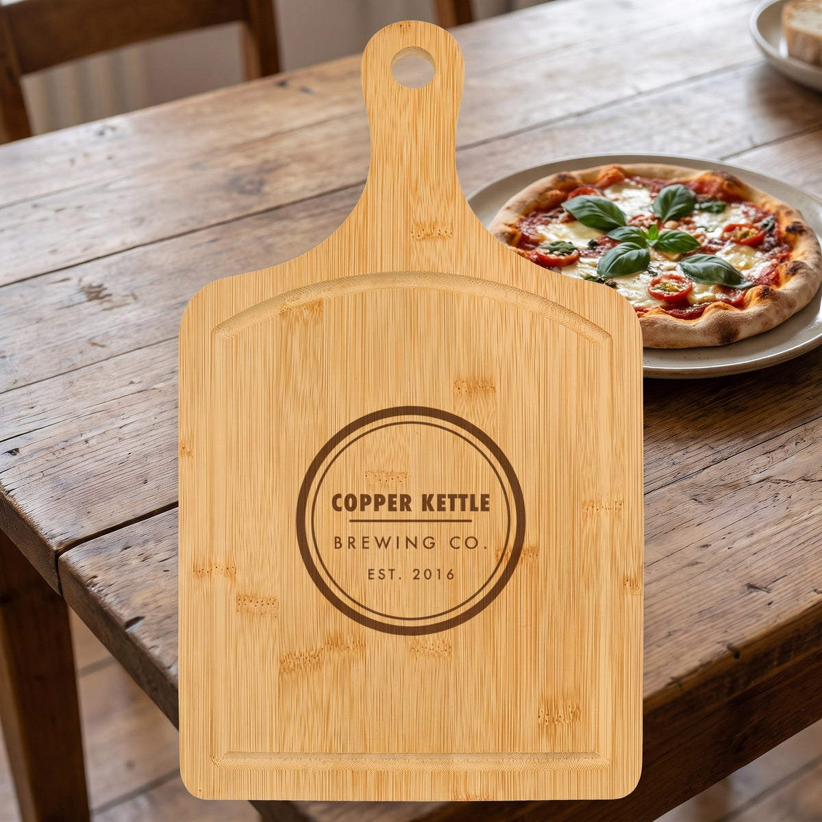 Custom Logo Bamboo Paddle Cutting Board with Drip Ring – with pizza with sample engraved logo