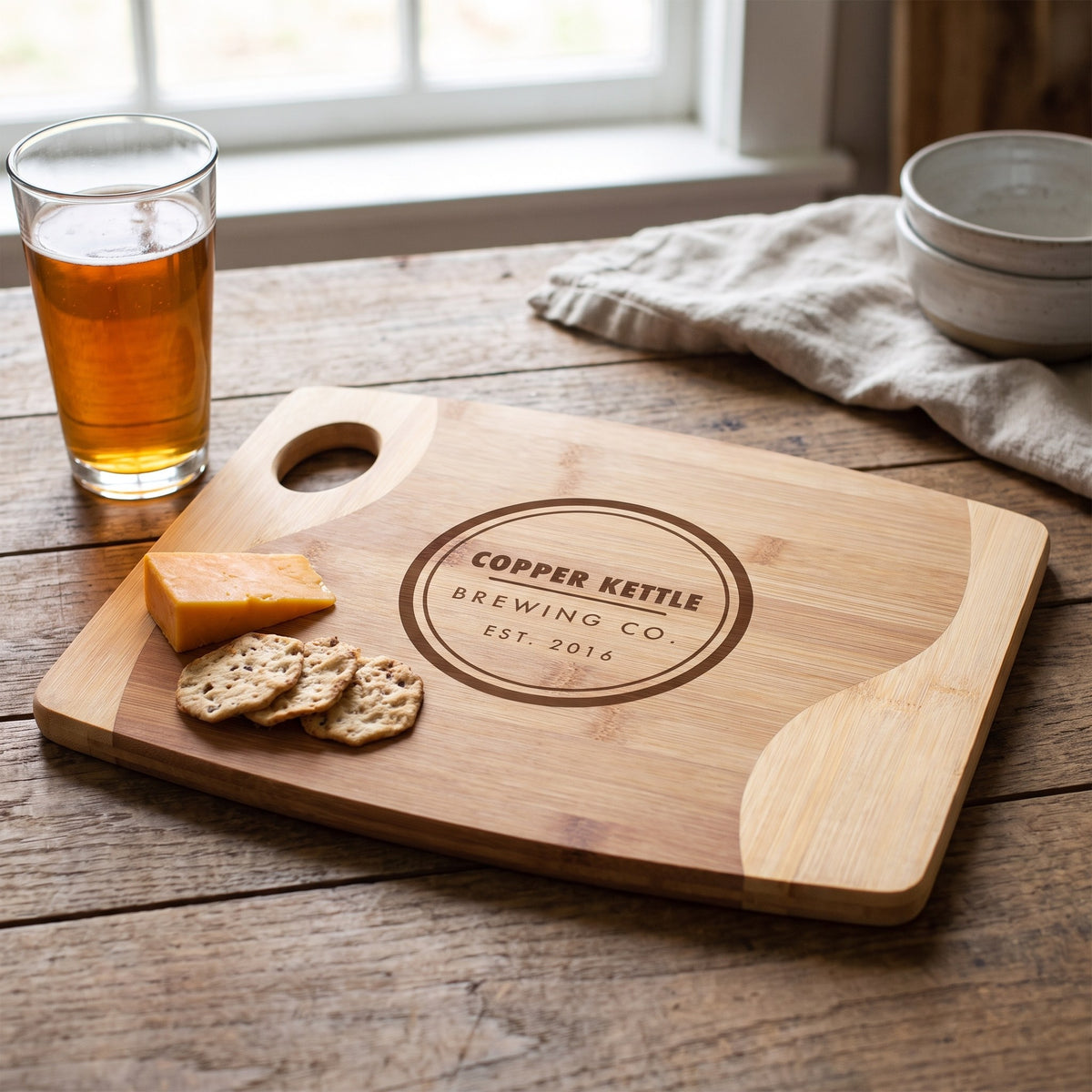 Custom Logo Two-Tone Bamboo Cutting Boards with Handle – with cheese and crackers with sample engraved logo
