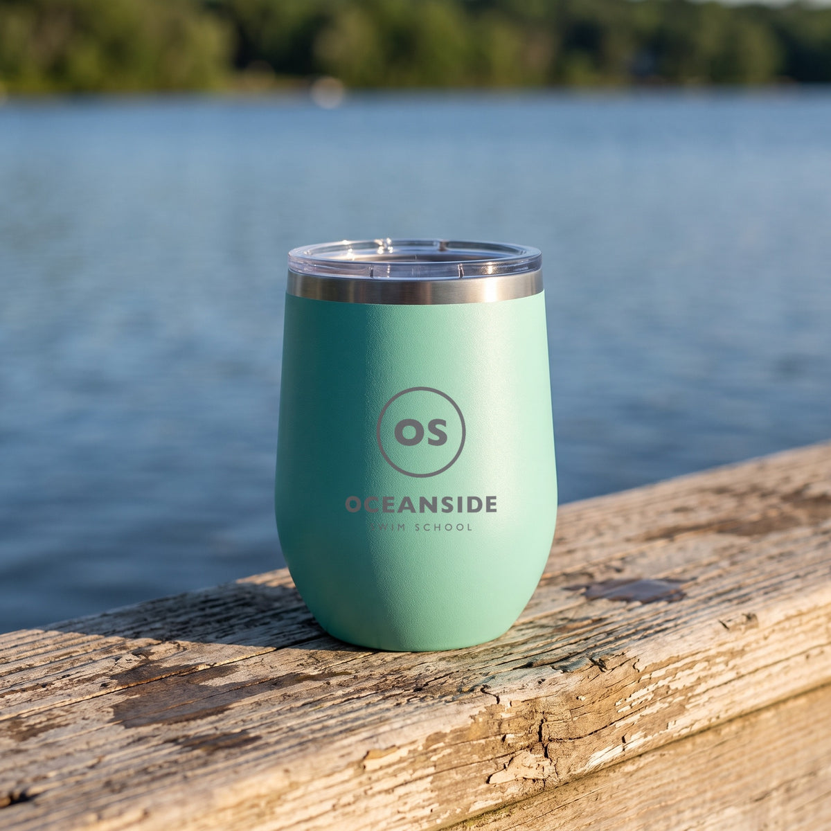 Custom Logo Polar Camel 12 oz Stemless Wine Tumbler, teal with an engraved sample logo on a lake dock