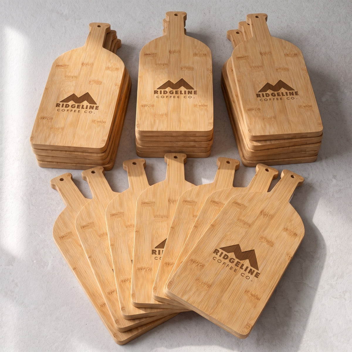 Custom Logo Bamboo Wine Bottle Board – bulk order of bamboo wine bottle boards, all engraved with the same sample logo