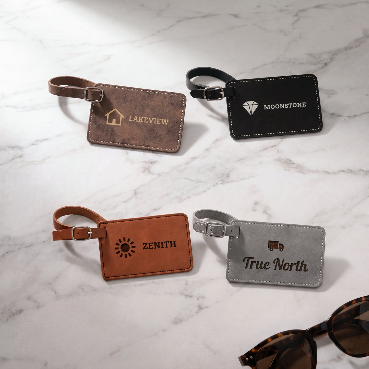 Custom Logo Leatherette Luggage Tags – rustic/gold, black/silver, rawhide and gray tags on marble, each engraved with a different sample logo