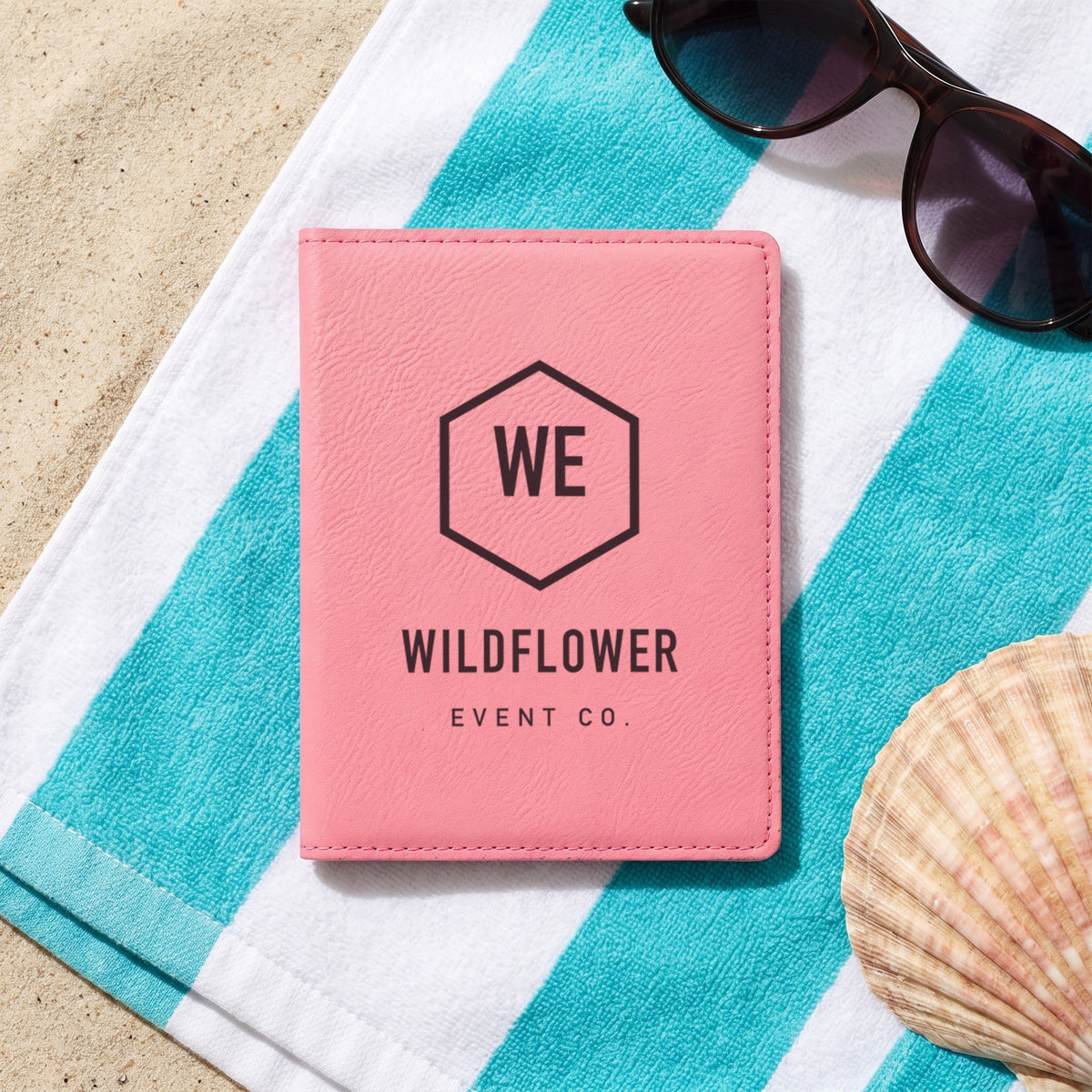 Custom Logo Leatherette Passport Holder, pink with an engraved sample logo on a beach towel