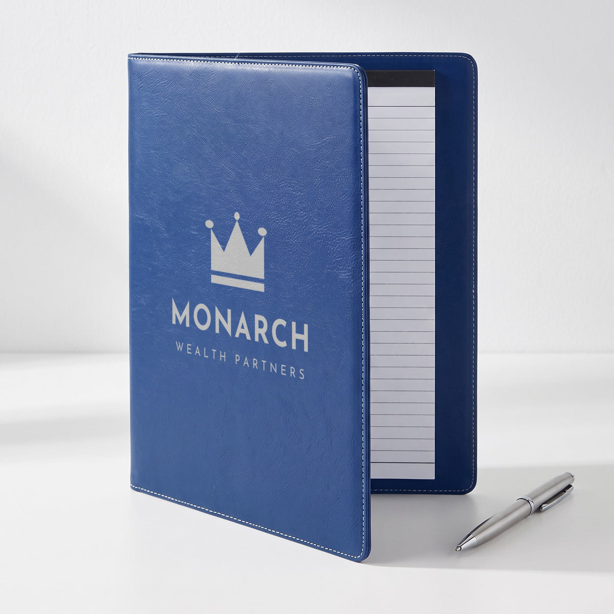Custom Logo Leatherette Portfolio, blue/silver opened to show the lined notepad, silver engraved sample logo on the cover