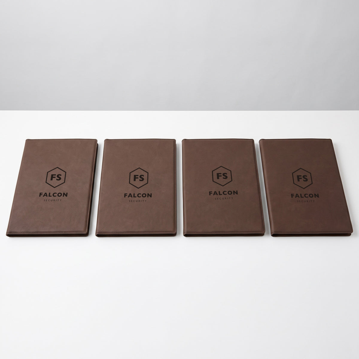 Custom Logo Leatherette Portfolio – five dark brown portfolios in bulk, engraved with the same sample logo