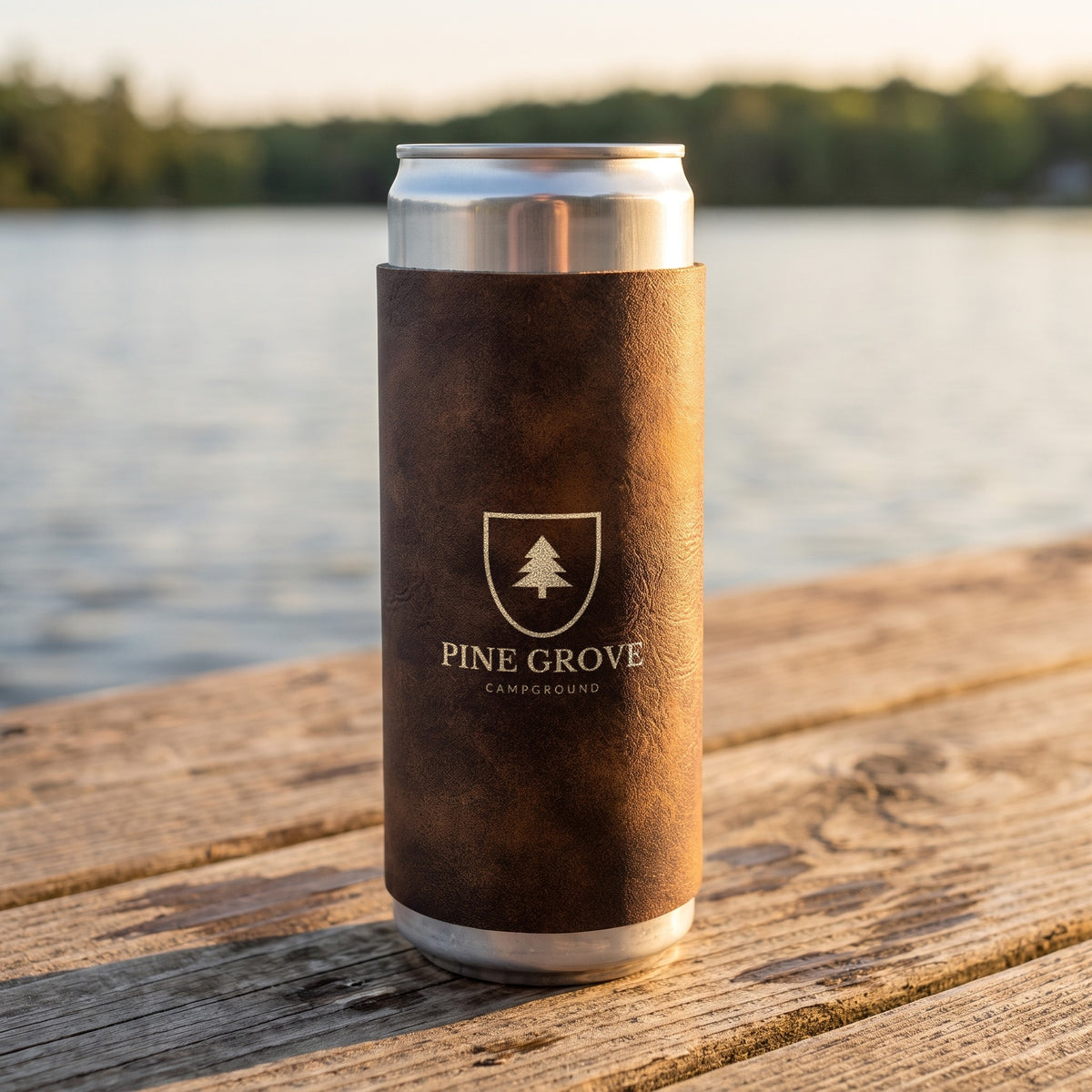 Custom Logo Leatherette Slim Can Coolers, rustic/gold with a gold engraved sample logo on a lake dock